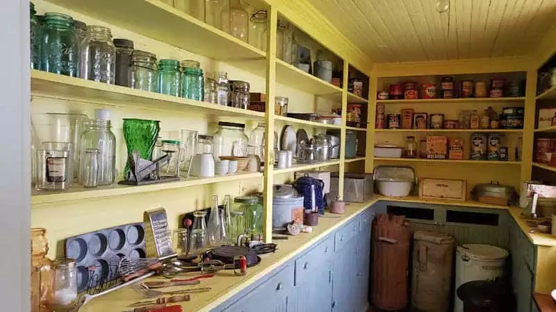 Bagg farm house pantry with shelves full of glass jars and various tins of supplies