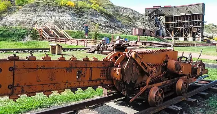 Coal mining vintage equipment on railwoad tracks with tipple in background. 