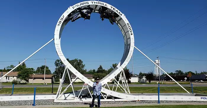 Giant white oval loop with two snowmobiles mounted at the top side. 