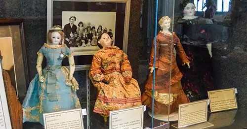 Four dolls from the 1800s along with some photos from Ruth Thomas, the collector.