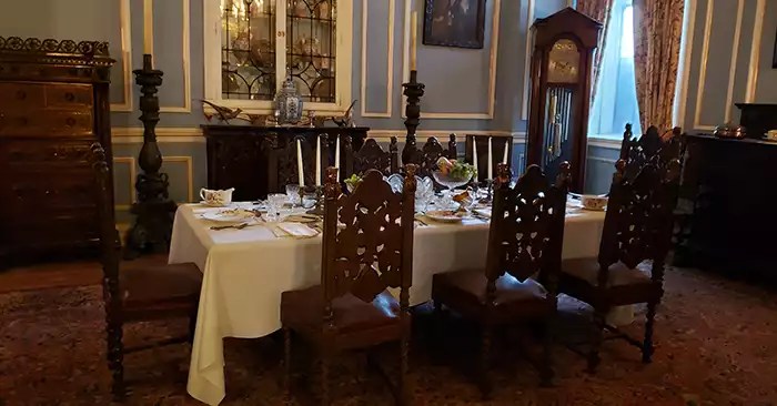 Six chairs and a table set for dinner with  place settings. 