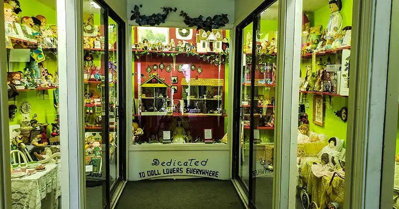 Glass cupboards full of dolls. 