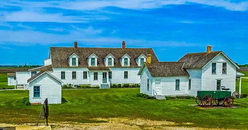 Farm house and outbuildings along with a well/pump and wagon.