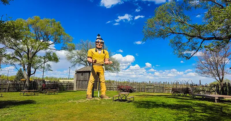 Large muffler man statue of a Native American with other artifacts inside the Fort Cody Trading Post stockade. 
