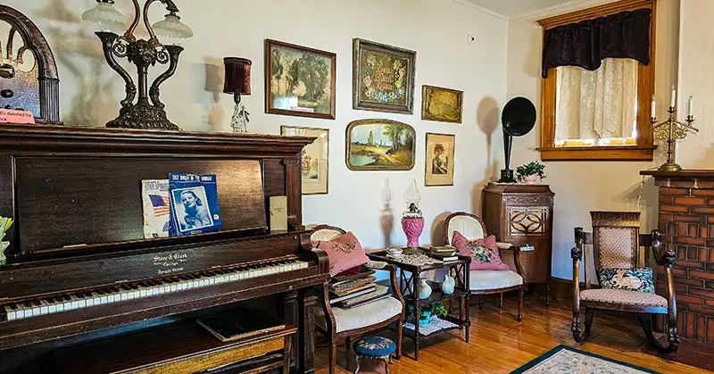 Family piano with comfy chairs and cushions.