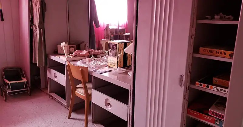 Pink built-in metal furnishings in a girl's room in a Lustron house