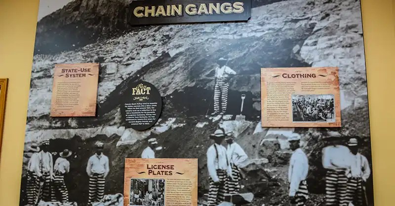 Historic Missouri State Penitentiary photo of prisoners in striped uniforms working outside.
