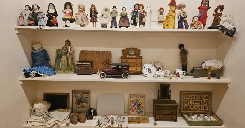 3 shelves of pioneer-era children's toys