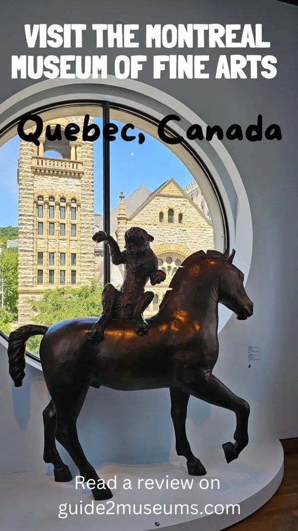 Horse statue in front a round window you can see a brick building through. 
