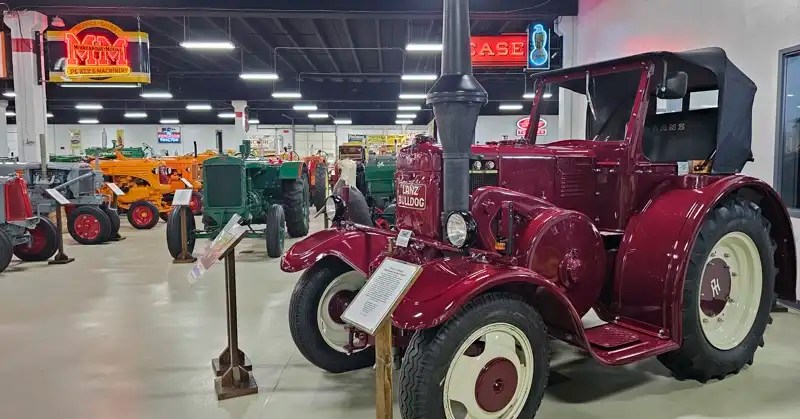 Dark red 1943 Bulldog Hot Bulb engine tractor in the foreground along with dozens of tractors in the background.